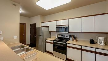 a kitchen with white cabinets and stainless steel appliances and a sink
